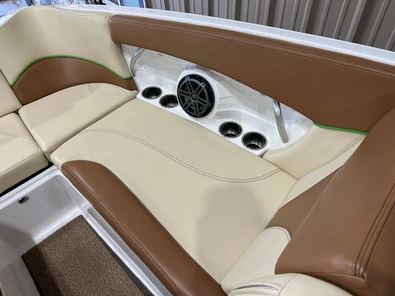 Slide: The Image of 2016 MasterCraft X26 boat interior with tan and cream seating, speaker, and cup holders. - 23