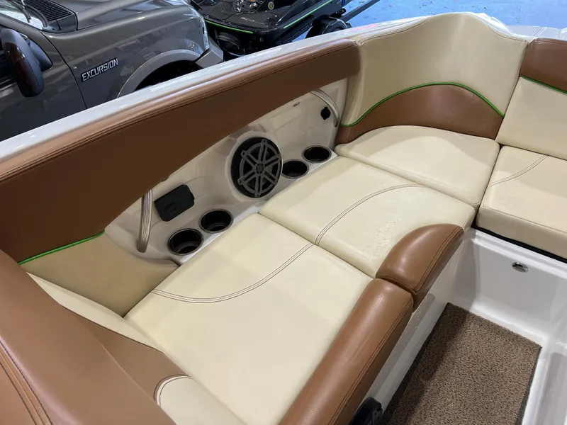Slide: The Image of 2016 MasterCraft X26 boat interior with tan and brown seating, cup holders, and speaker. - 24