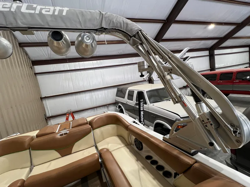 Slide: The Image of 2016 MasterCraft X26 boat interior in a garage with vehicles. - 32