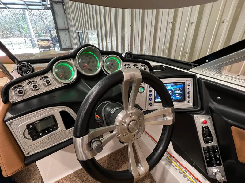 Slide: The Image of 2016 MasterCraft X26 dashboard with steering wheel and illuminated gauges. - 40