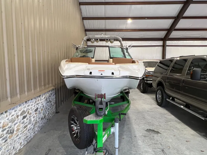 Slide: The Image of 2016 MasterCraft X26 boat on green trailer in storage facility. - 6