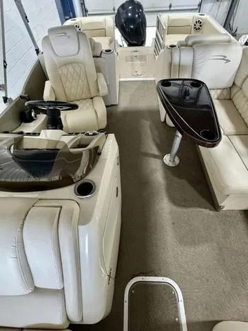 Slide: The Image of 2013 Bennington 2575 R boat interior with beige seating and steering console. - 11
