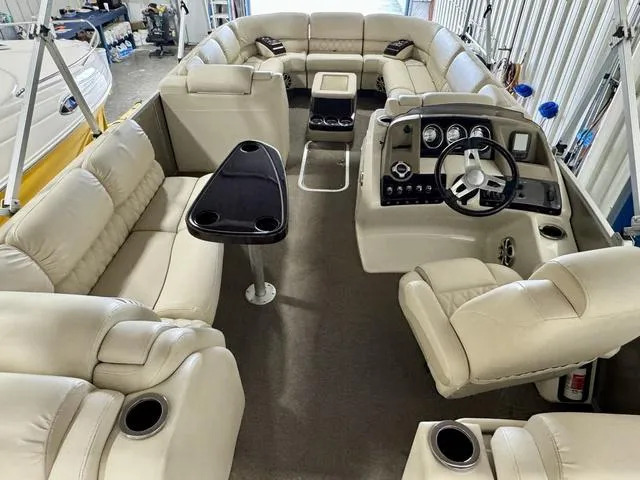 Slide: The Image of 2013 Bennington 2575 R pontoon boat interior with beige seating and modern dashboard. - 12