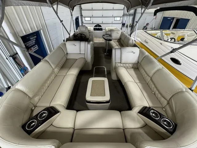 Slide: The Image of 2013 Bennington 2575 R pontoon boat interior with beige seating and cup holders. - 17