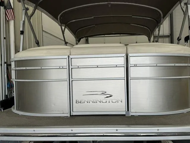 Slide: The Image of 2013 Bennington 2575 R pontoon boat with canopy in a showroom. - 2
