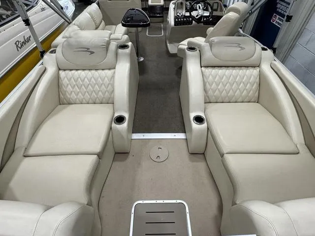 Slide: The Image of 2013 Bennington 2575 R boat interior with beige leather seating and modern dashboard. - 25