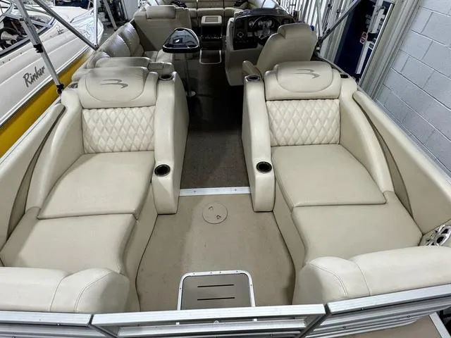Slide: The Image of 2013 Bennington 2575 R boat interior with beige leather seating and cup holders. - 29