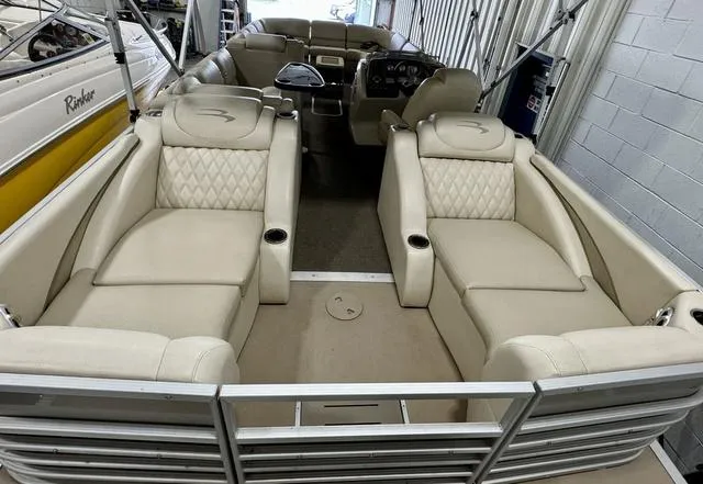 Slide: The Image of 2013 Bennington 2575 R pontoon boat with beige leather seating in a storage facility. - 30