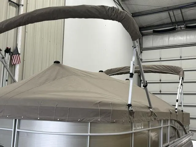 Slide: The Image of 2013 Bennington 2575 R pontoon boat with beige cover in a garage. - 37