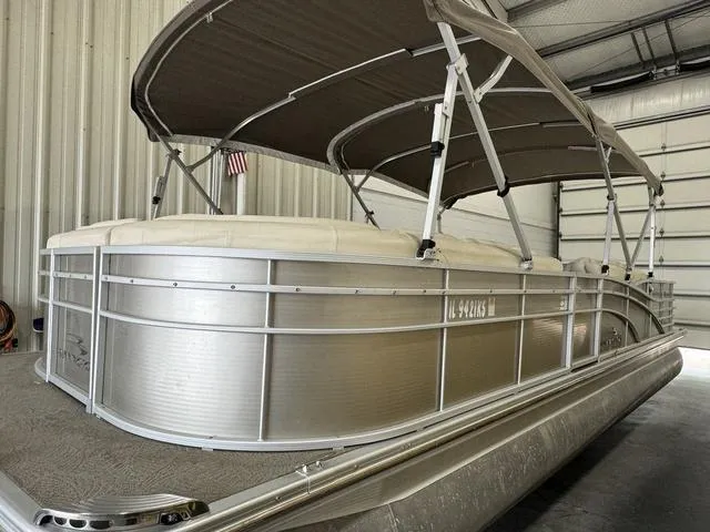 Slide: The Image of 2013 Bennington 2575 R pontoon boat in storage, featuring a sleek aluminum design. - 4