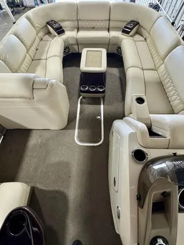 Slide: The Image of 2013 Bennington 2575 R pontoon boat interior with beige seating and central table. - 9