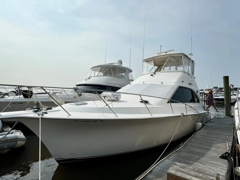 Slide: The Image of 1993 Ocean Yachts 42 Super Sport docked at marina, sleek white design. - 1