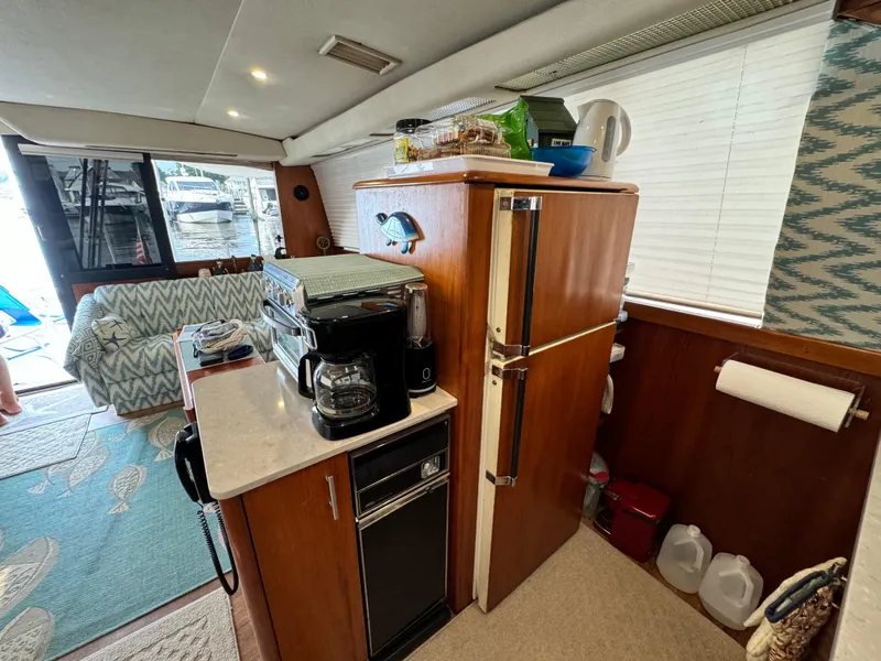 Slide: The Image of Interior of a 1993 Ocean Yachts 42 Super Sport, featuring a compact kitchen area. - 16