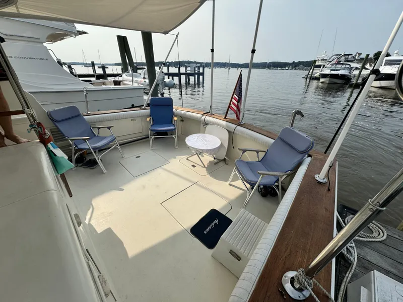 Slide: The Image of 1993 Ocean Yachts 42 Super Sport boat deck with chairs and table, docked at marina. - 2