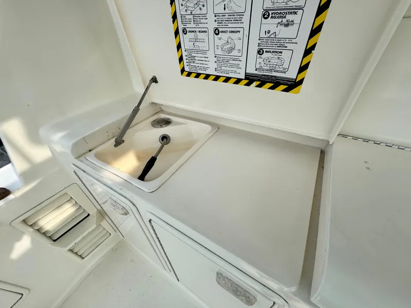 Slide: The Image of 1993 Ocean Yachts 42 Super Sport boat sink area with storage and safety instructions. - 4