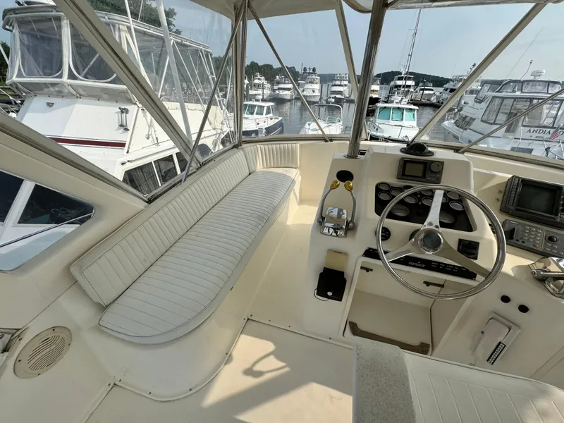 Slide: The Image of 1993 Ocean Yachts 42 Super Sport helm with steering wheel and navigation equipment in a marina. - 6