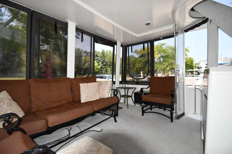Slide: The Image of 1997 Carver 405 Motor Yacht interior with brown seating and large windows. - 13