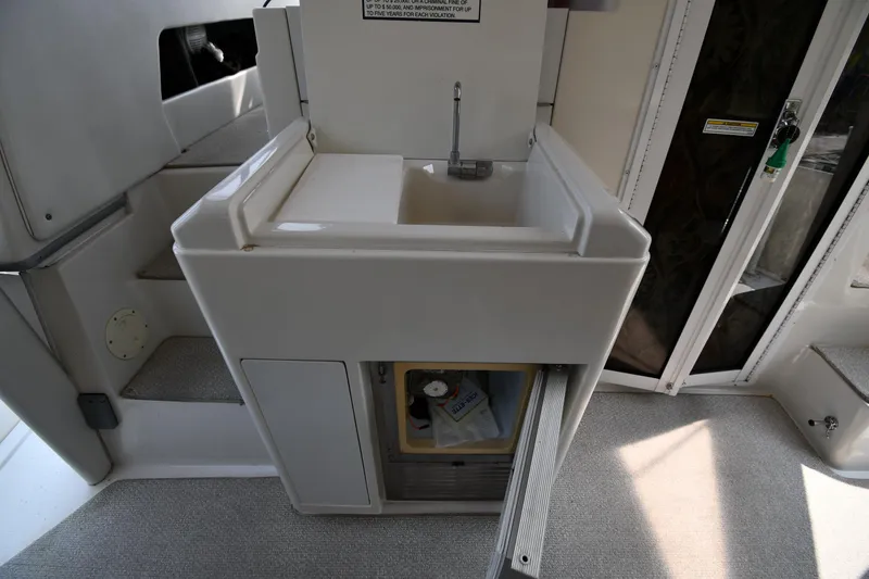 Slide: The Image of 1997 Carver 405 Motor Yacht interior sink area with storage and steps. - 14