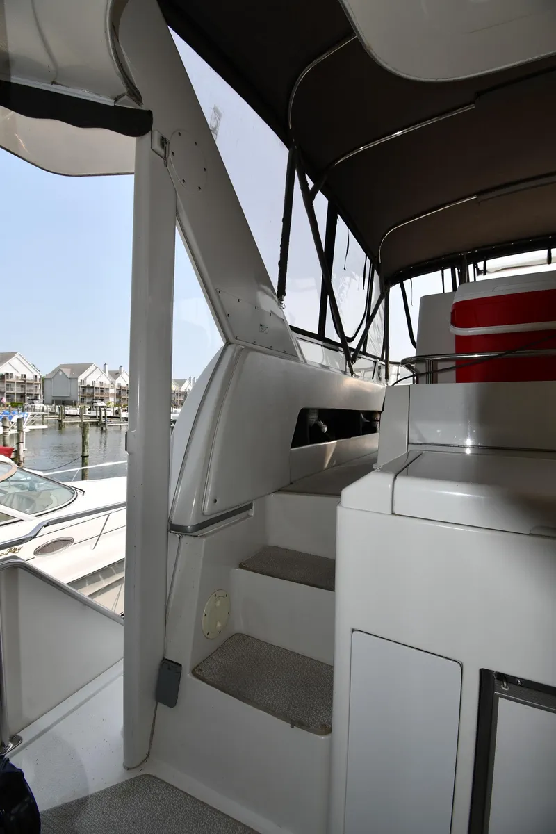 Slide: The Image of 1997 Carver 405 Motor Yacht interior with stairs and marina view. - 16