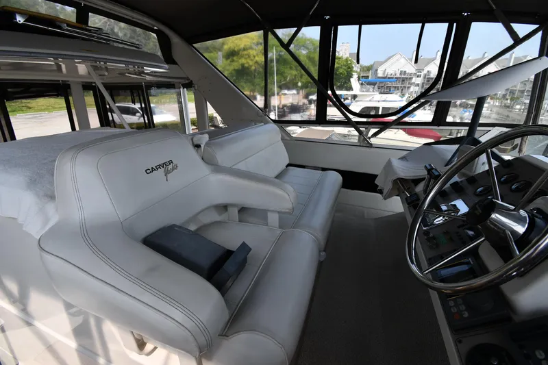 Slide: The Image of 1997 Carver 405 Motor Yacht interior with helm and seating area. - 21