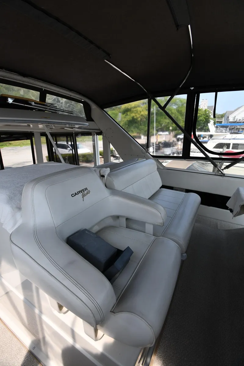 Slide: The Image of 1997 Carver 405 Motor Yacht interior with white seating and large windows. - 22