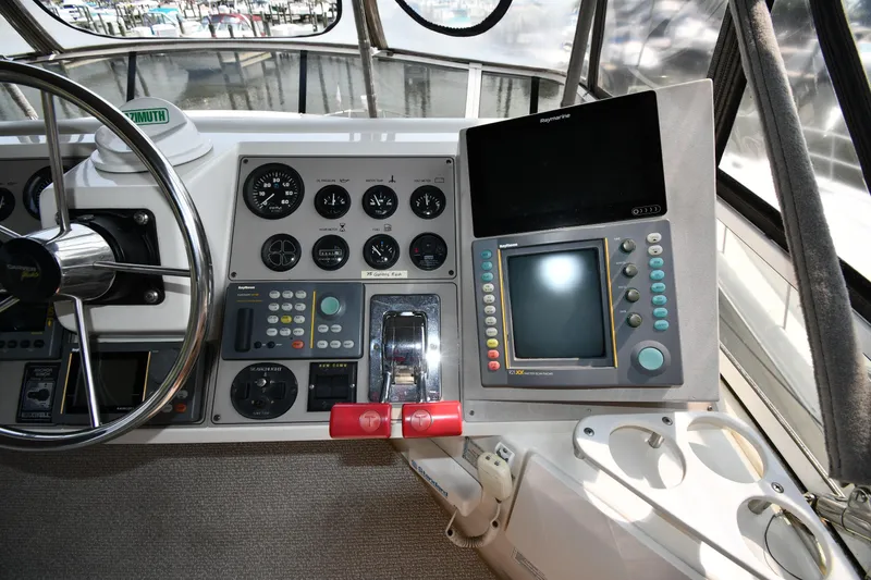Slide: The Image of Control panel of a 1997 Carver 405 Motor Yacht with steering wheel and navigation equipment. - 23