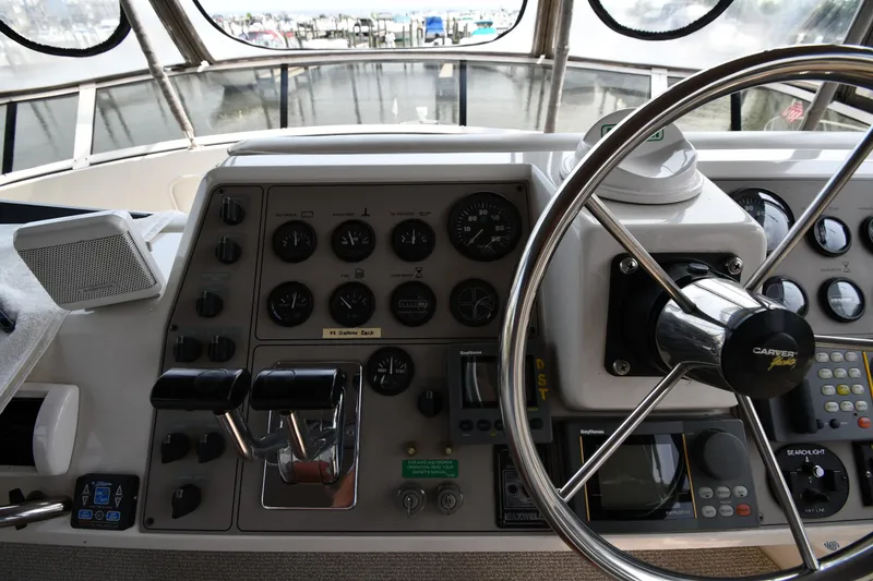 Slide: The Image of 1997 Carver 405 Motor Yacht helm with steering wheel and control panel. - 25