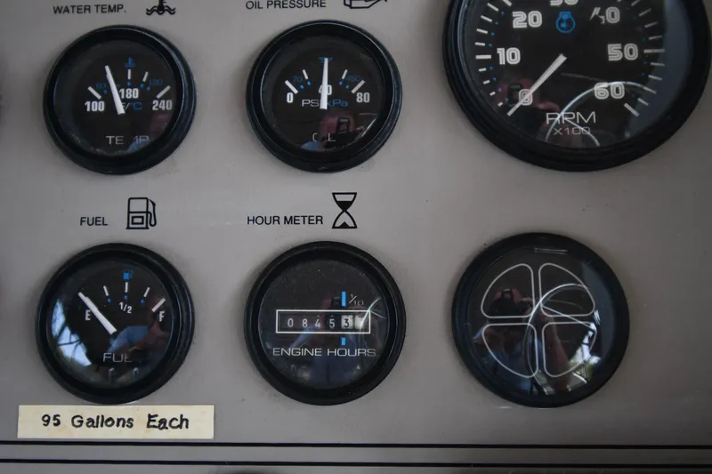 Slide: The Image of Dashboard gauges of a 1997 Carver 405 Motor Yacht, showing fuel, RPM, and engine hours. - 26