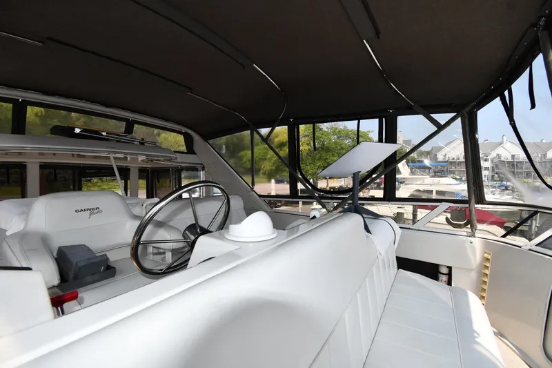 Slide: The Image of 1997 Carver 405 Motor Yacht interior with steering wheel and seating area. - 28