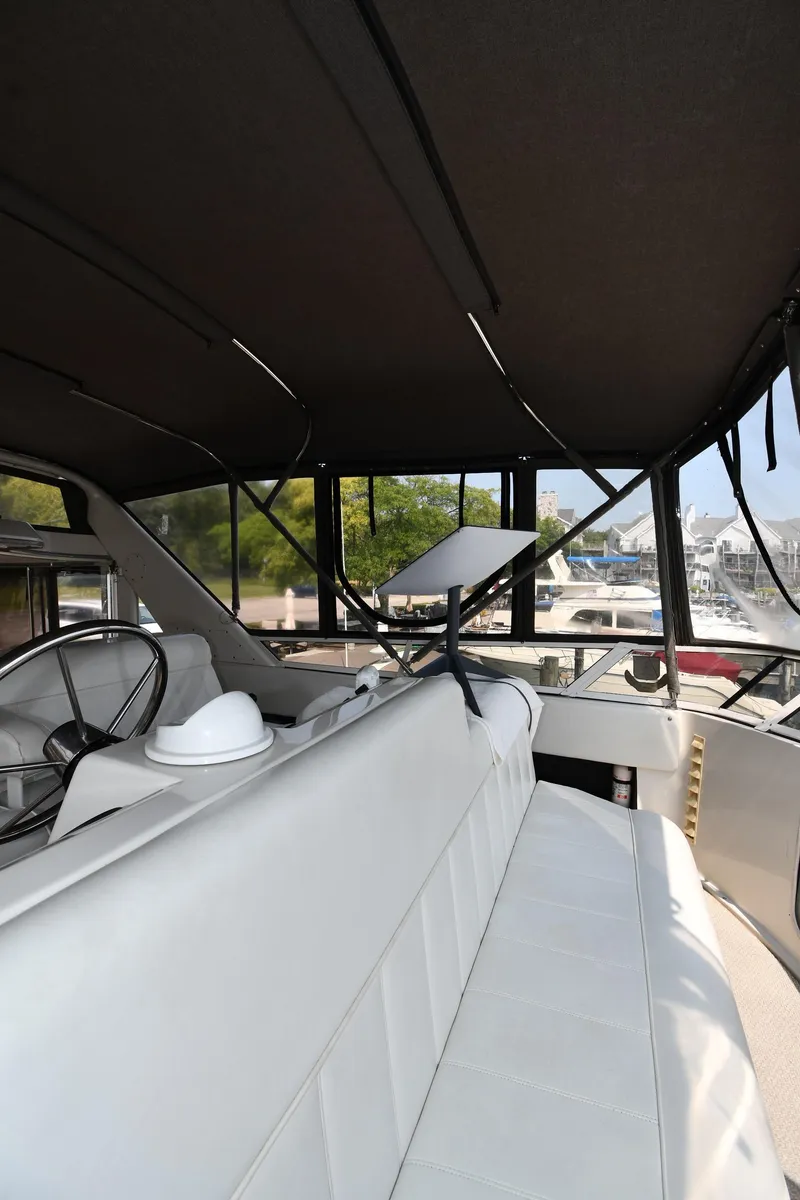 Slide: The Image of 1997 Carver 405 Motor Yacht interior with white seating and helm. - 30