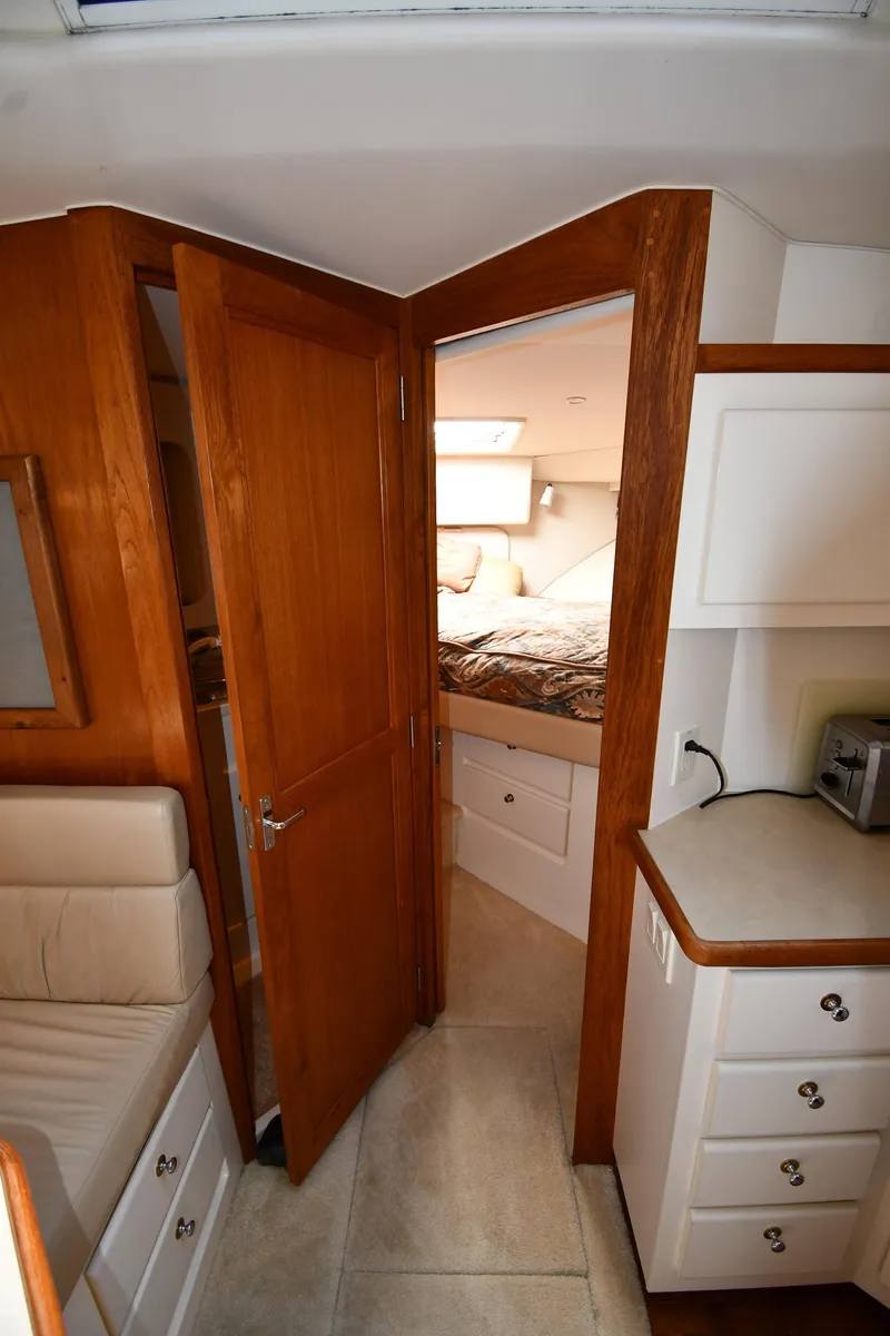 Slide: The Image of Interior of 1997 Carver 405 Motor Yacht with wood cabinetry and cozy bedroom. - 33