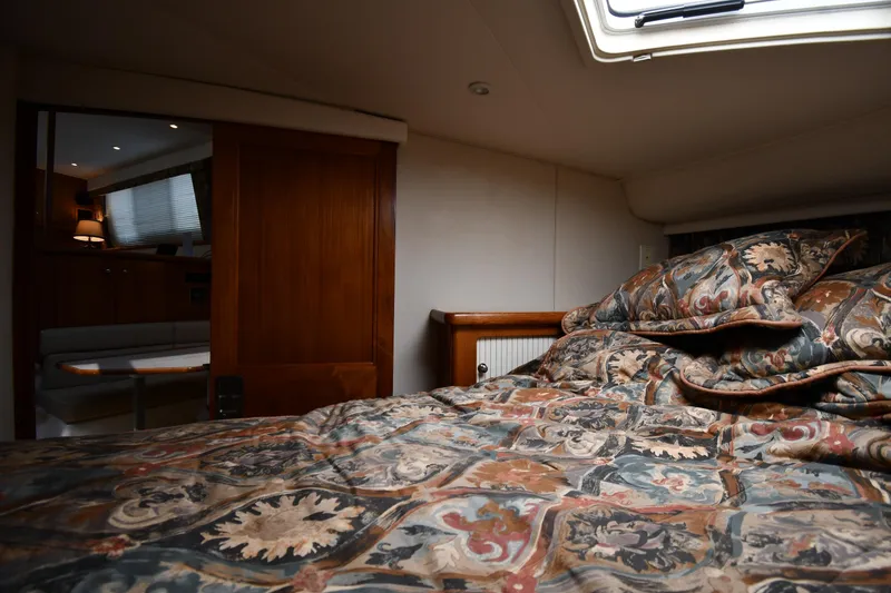 Slide: The Image of Interior cabin of 1997 Carver 405 Motor Yacht with patterned bedding and wooden accents. - 37