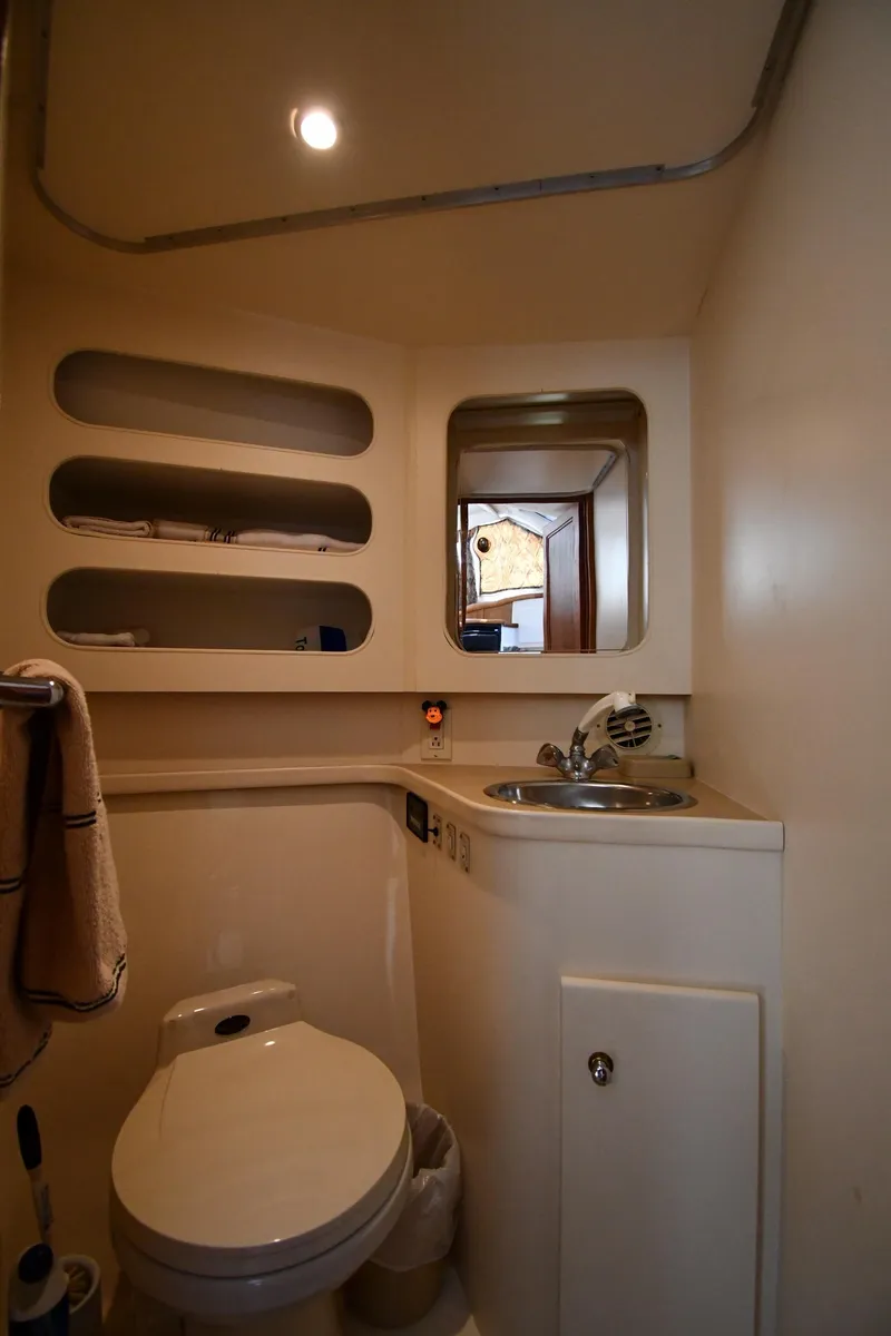 Slide: The Image of 1997 Carver 405 Motor Yacht bathroom with sink, toilet, and shelves. - 40