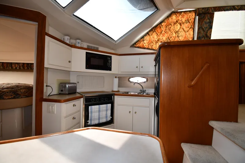 Slide: The Image of 1997 Carver 405 Motor Yacht interior kitchen with skylight, microwave, and compact design. - 41