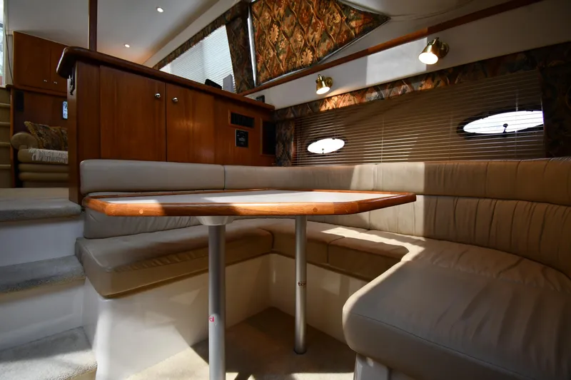 Slide: The Image of 1997 Carver 405 Motor Yacht interior with cozy dining area and wooden table. - 45