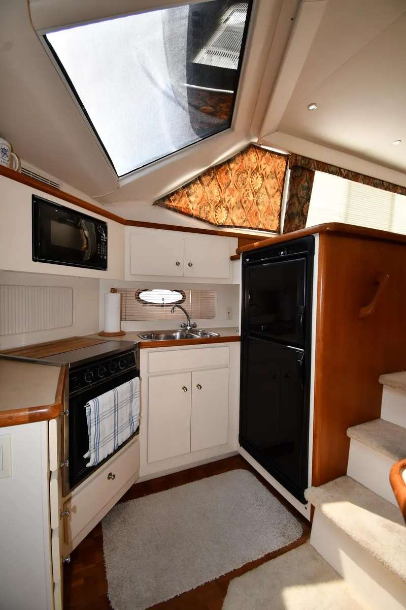 Slide: The Image of 1997 Carver 405 Motor Yacht kitchen with skylight, microwave, and compact appliances. - 48