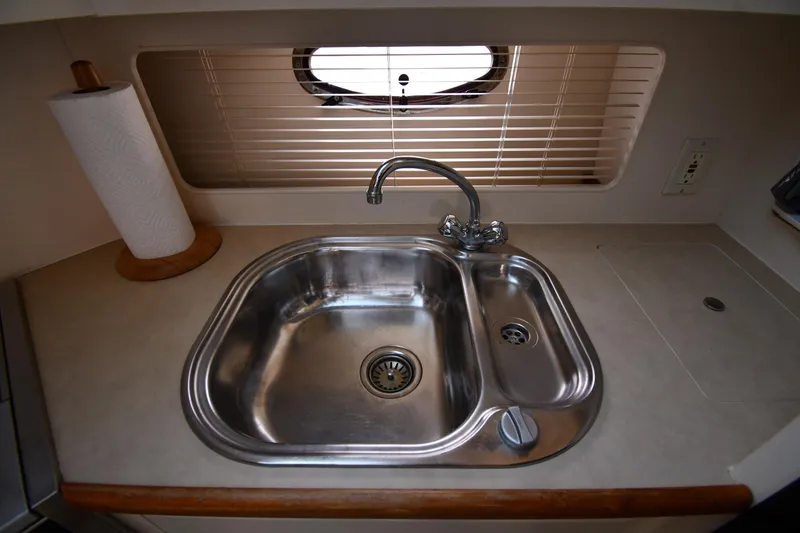 Slide: The Image of 1997 Carver 405 Motor Yacht kitchen sink with faucet and paper towel holder. - 49