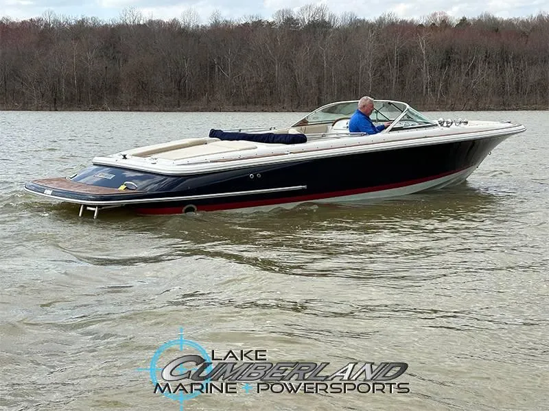 Slide: The Image of 2009 Chris-Craft Launch 25 Heritage Edition boat cruising on a lake with wooded shoreline. - 5