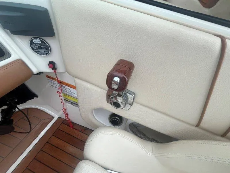 Slide: The Image of Interior of 2009 Chris-Craft Launch 25 Heritage Edition boat, featuring beige upholstery and wooden accents. - 51