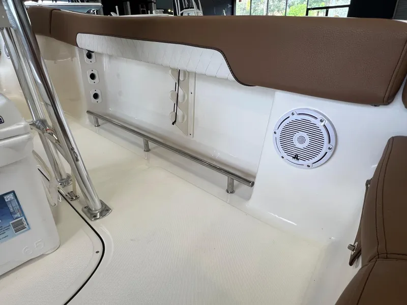 Slide: The Image of 2024 Pioneer 202 Islander boat interior with brown seating and built-in speaker. - 13