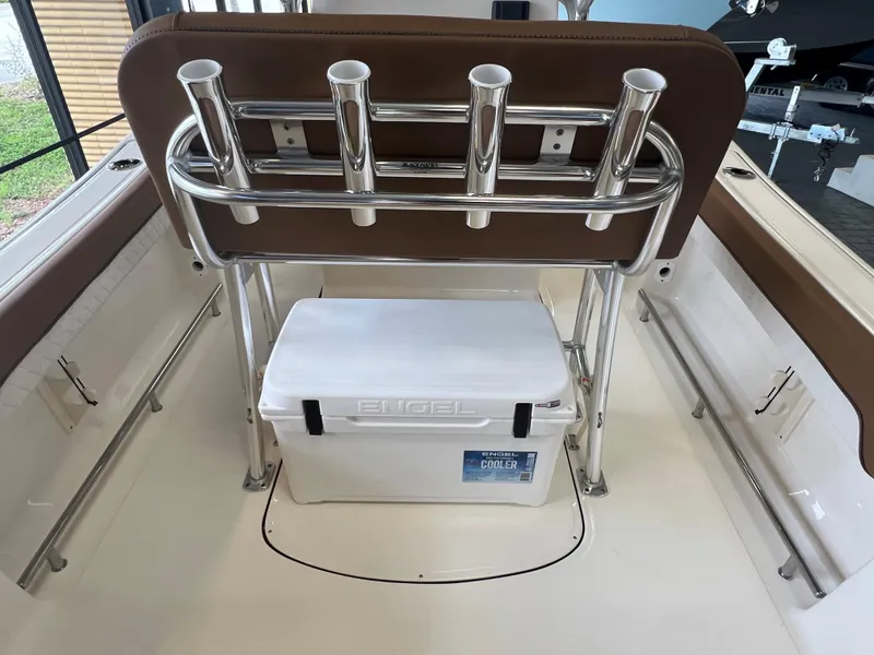 Slide: The Image of 2024 Pioneer 202 Islander boat interior with rod holders and cooler. - 14