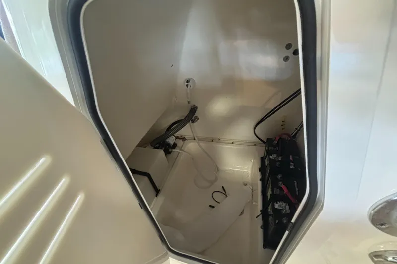 Slide: The Image of 2024 Pioneer 202 Islander boat storage compartment with battery setup. - 15