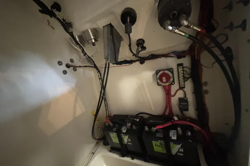Slide: The Image of 2024 Pioneer 202 Islander boat battery compartment with wiring and components. - 17