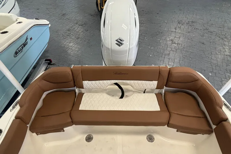 Slide: The Image of 2024 Pioneer 202 Islander boat with brown and white seating, Suzuki outboard motor. - 18