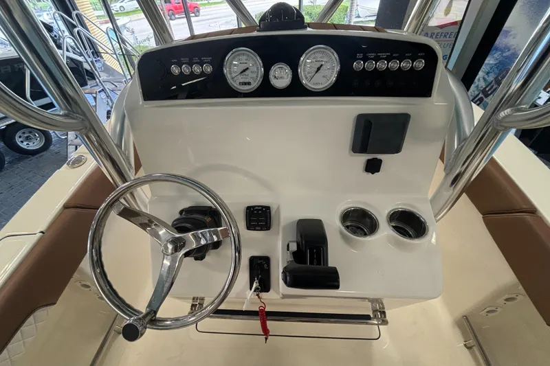 Slide: The Image of 2024 Pioneer 202 Islander boat dashboard with steering wheel and gauges. - 19