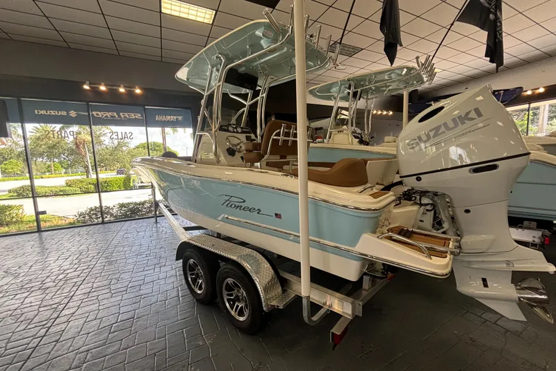 Slide: The Image of 2024 Pioneer 202 Islander boat with Suzuki engine on display in showroom. - 2