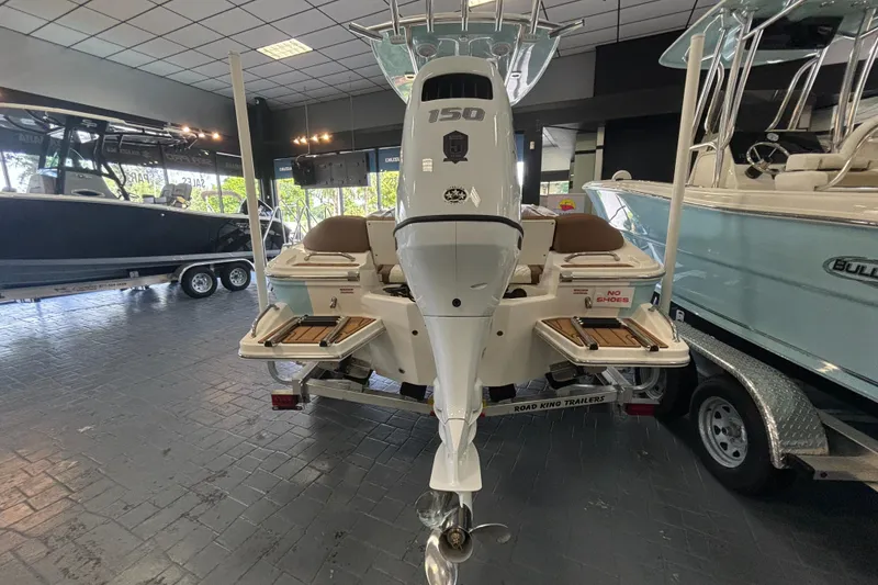 Slide: The Image of 2024 Pioneer 202 Islander boat displayed in showroom, rear view with motor. - 3