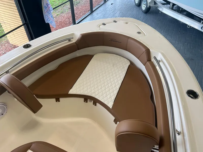 Slide: The Image of 2024 Pioneer 202 Islander boat interior with brown and white cushioned seating. - 6