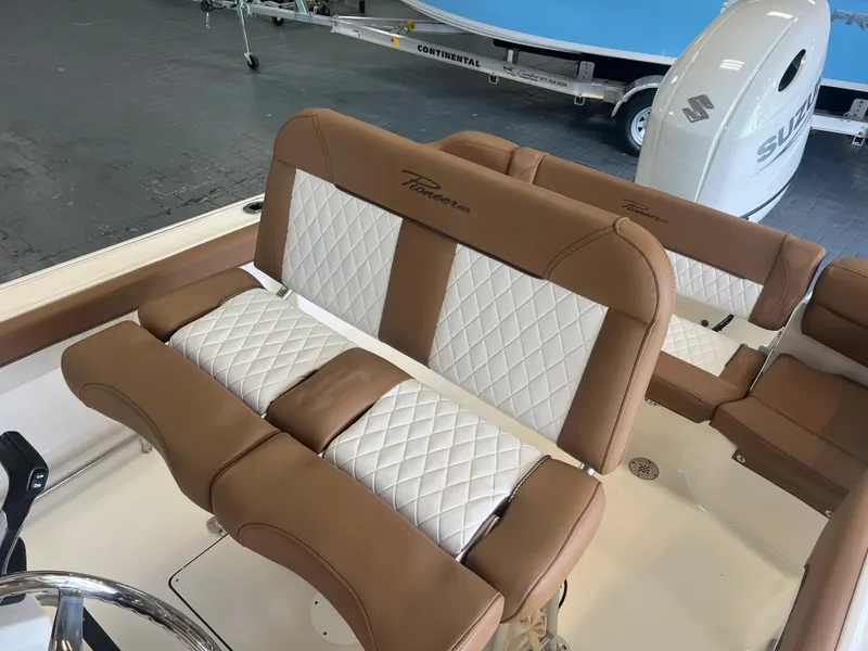 Slide: The Image of 2024 Pioneer 202 Islander boat interior with brown and white cushioned seating. - 8