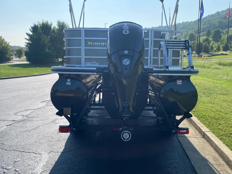 Slide: The Image of 2024 Ranger Reata 223C pontoon boat with outboard motor, parked on a sunny day. - 4